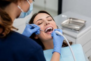 Paciente en consulta de dentista recibiendo limpieza dental profesional.